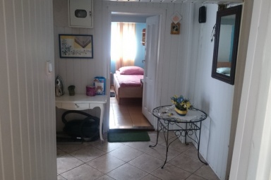 przedpok&oacute;j z widokiem na wejście do sypialni nr 2, stojąc w drzwiach pokoju telewizyjnego. Przed lustrem z prawej jest wejście do kuchni.