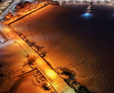 nocne zdjęcie z g&oacute;ry, oświetlony port / plaża zimą